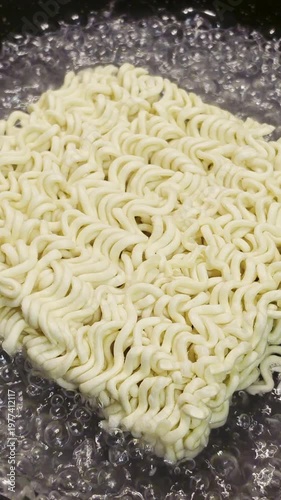 Dried Instant Noodles Close up Cooking in Boiled Water in Frying Pan
