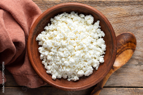 Tvorog, cottage cheese in bowl on wooden table background. Top view