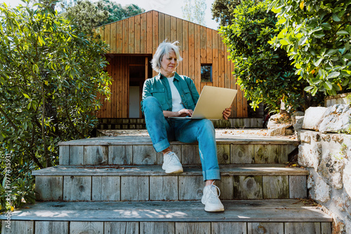 Mature woman enjoying tranquil cabin garden lifestyle