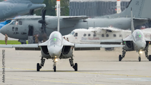 Flying in formation, Alenia Aermacchi M-346 Master jet trainers showcase their agility during a military exercise at a vibrant airfield