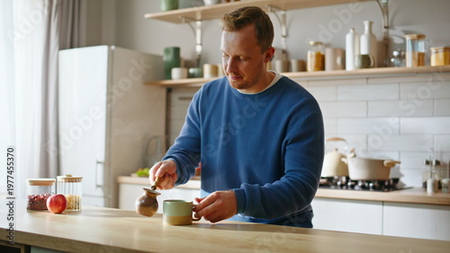 Photos Man filling coffee cup holding coffeepot at modern kitchen interior closeup