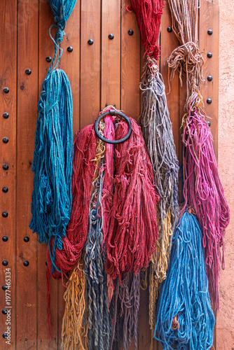 Colorful dyed wool yarn hanging on wooden door