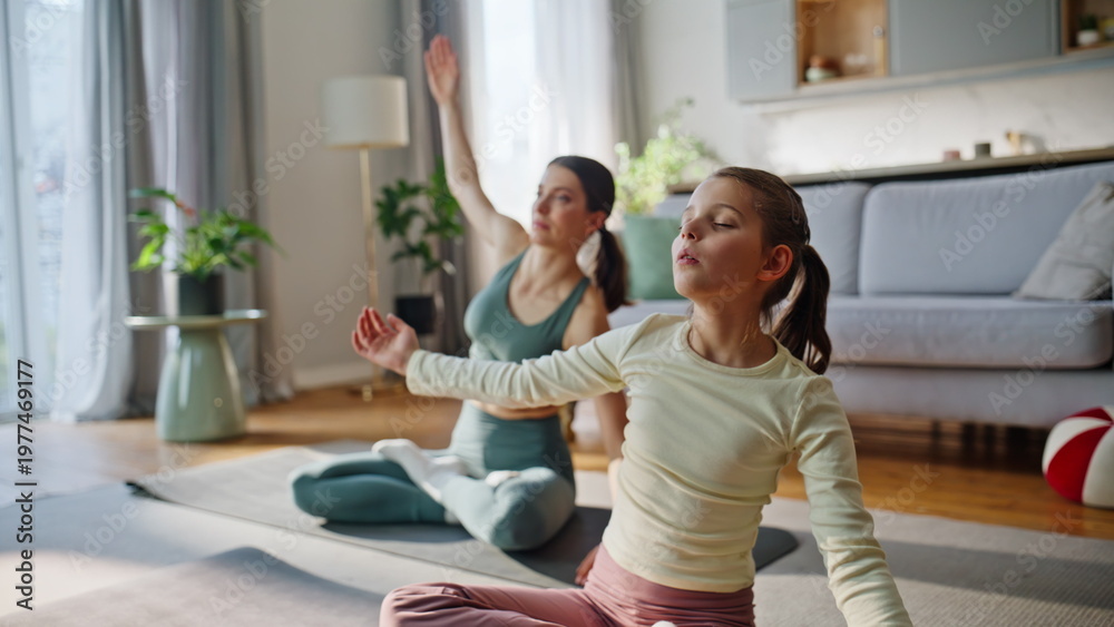Obraz premium Flexible aunt kid stretching indoors. Family sitting lotus pose bending body