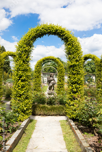 Elegant italian garden in Villa Pallavicino. Traditional vintage design, romantic style, with blue sky during spring.
