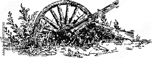 Old wooden wagon wheel lying in grass and plants, vintage rustic countryside farming equipment