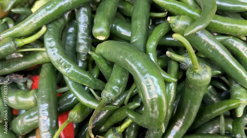 Green chilies and a few red chilies create a vibrant and spicy food background