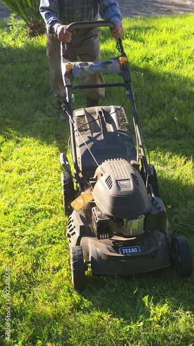 man with lawnmower cutting the grass