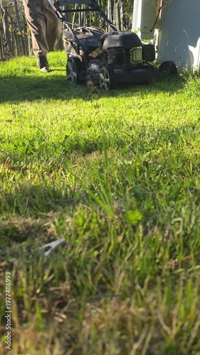 man with lawnmower cutting the grass