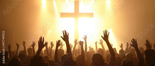 Wide angle silhouette of crowd with raised hands in front of illuminated cross. Concept of worship, faith, unity, spirituality and religious gathering.
