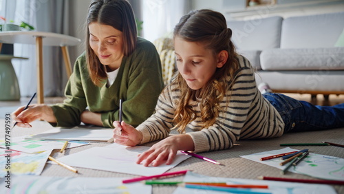 Tableau sur toile Joyful caregiver sketching child enjoying creative home weekend pastime closeup