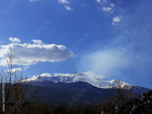 Schilderij op canvas L'Etna, avvolta nel suo manto bianco, si lascia accarezzare dal sole