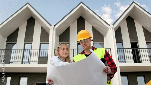Foto Team of construction professionals viewing blueprints on job site