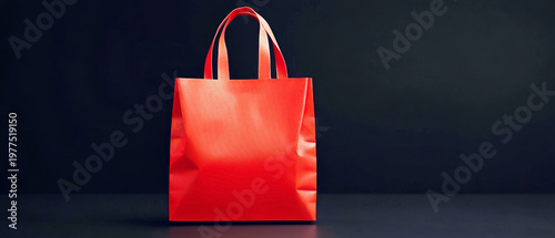 Vibrant red shopping bag with handles against a dark background, symbolizing retail, sales, and consumer culture with ample copy space