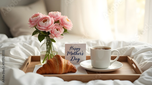 Mother's Day breakfast with pink peonies, coffee, croissant and handwritten cursive card on vintage wooden tray with white linen in soft morning light. Romantic cozy vintage mood