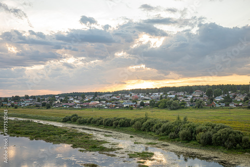 Bilde på lerret View to waterlogged river bank with near rural settlement at sunset