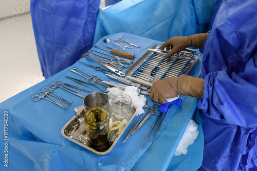Close-up of Orthopedic Surgery Instruments on a Sterile Table with Surgeon's Hands Preparing for Traumatology Operation in Operating Room