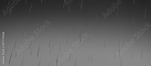 Abstract streaks of light falling downwards against a dark grey background
