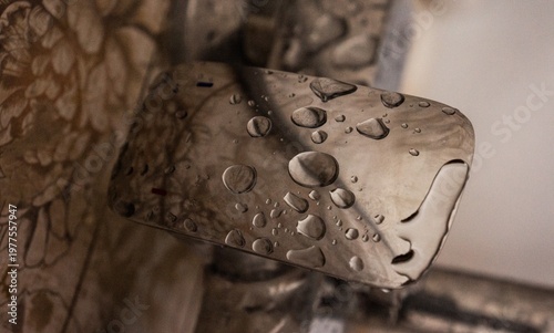 Water droplets on a metallic surface with floral background