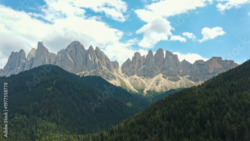 Slika na platnu Odle group mountains towering above green forest landscape