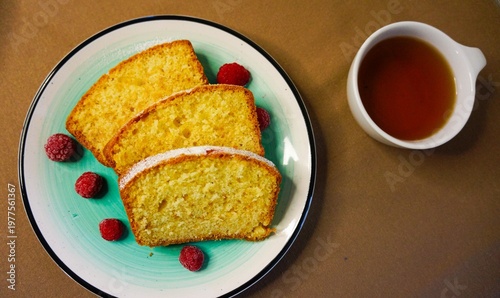 Delicious cake slices with raspberries and syrup on a plate