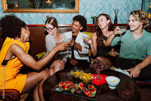 Fotografie Diverse friends enjoying cocktails and toasting during a social party
