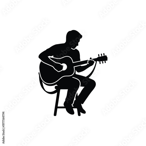 Silhouette of a man sitting on a stool, playing an acoustic guitar