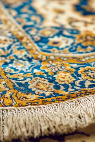 A detailed view of a blue and gold rug, perfect for interior design and decoration. vertical frame