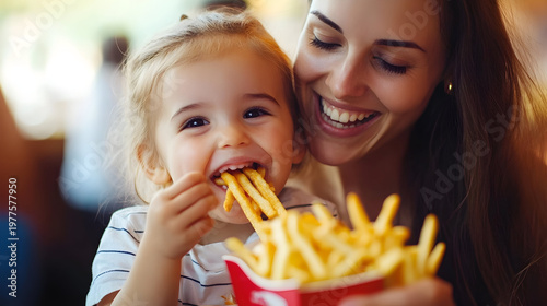 Mother and child sharing french fries happily