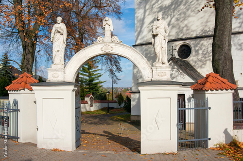 Gate with sculptures in front of Church of Exaltation of Holy Cross (kościół Podwyższenia Krzyża Świętego). Sławków, Poland.
