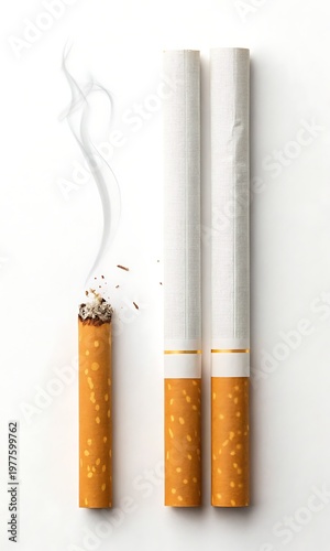 Close-up of burning cigarette with smoke and two unlit cigarettes