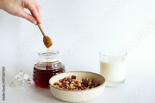Sweet breakfast, honey dripping into a bowl of cereal flakes.