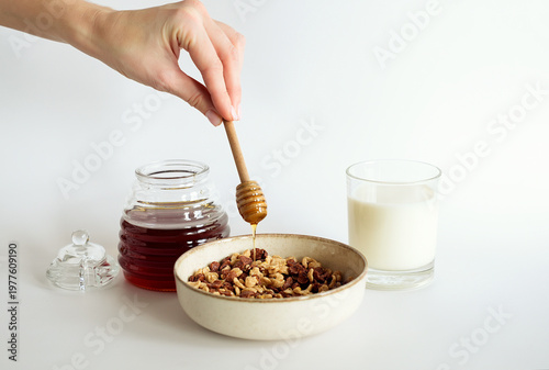 Sweet breakfast, honey dripping into a bowl of cereal flakes.