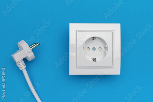 White Electrical Plug and Socket on Blue Background - Clean Energy Concept