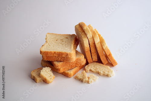 Sliced white bread and crumbs on white background.