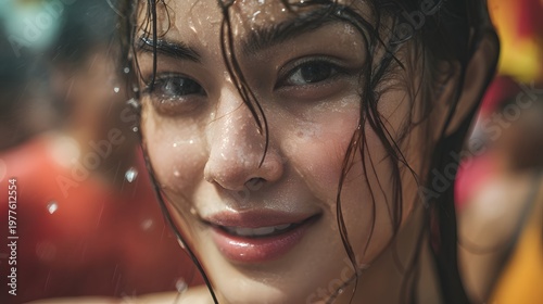 Close-up portrait of a smiling girl with wet hair in rain