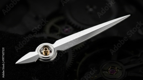Precision silver watch hand in a detailed macro view over a dark, blurred watch movement.
