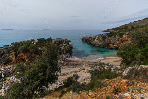 Aquarium bay with beach and rock formations on the Adriatic sea coast with turquoise colored water near Himare, Albania