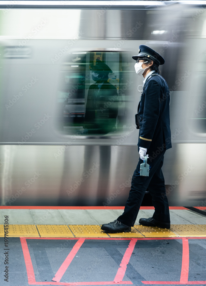 Fototapeta premium silhouette of Japanese train conductor on subway rail platforms with fast moving train