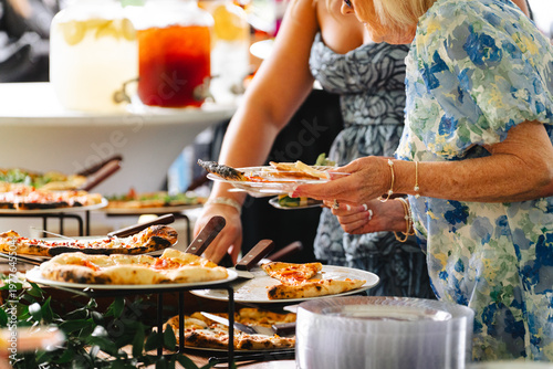 Valokuva People serving wood fired pizza at a catered outdoor event