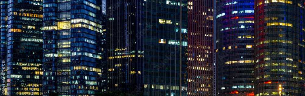 Obraz premium Multi-stories office building at night with worker working overtime. late night at office. lighting and working people within