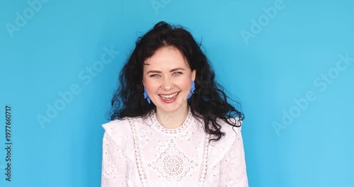 Woman on blue background struggling with intense exhaustion fanning herself changing to joyous laughter, expressive female dramatizing emotional relief and transition from sadness to happiness