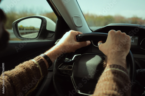 Obraz na plátně Man driving car on highway, hands gripping steering wheel, traveling and commuti