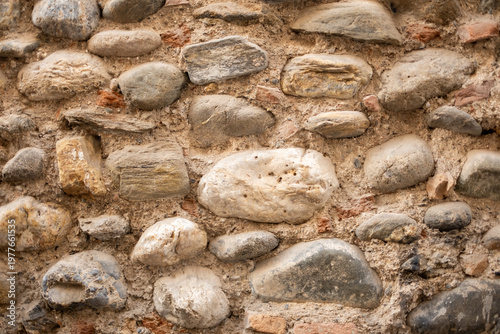 Foto Ancient stone wall showing weathered masonry texture with natural river stones a