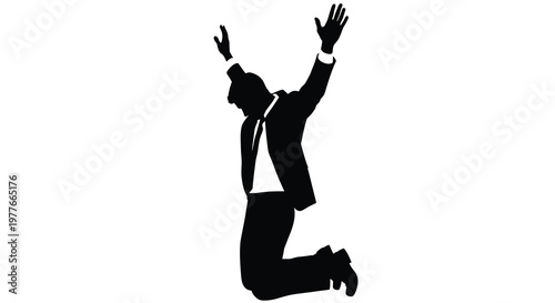 Jubilant businessman leaping in the air with arms raised a dark silhouette