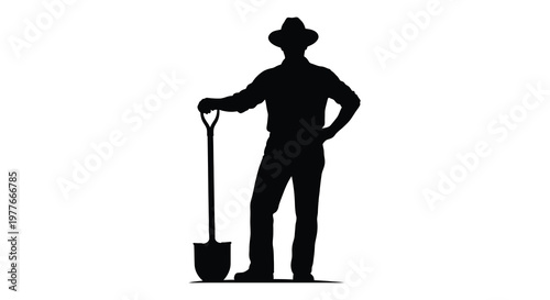 A lone cowboy stands with a shovel a striking dark silhouette