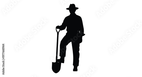 A solitary farmer stands with a shovel a striking black silhouette