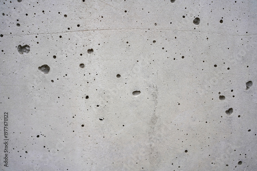 Grey concrete wall texture with porous holes and industrial weathered surface background