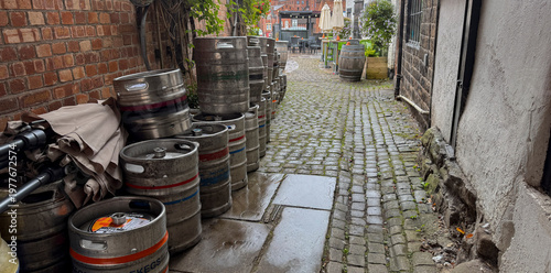 Leek Staffordshire December 20th 2024 Beer Kegs Lined Outside a Rainy Pub on a Cobblestone Alleyway