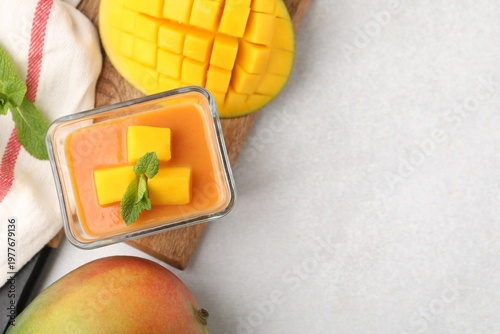 Konstfotografi Delicious mango panna cotta with mint and fruits on light grey table, flat lay
