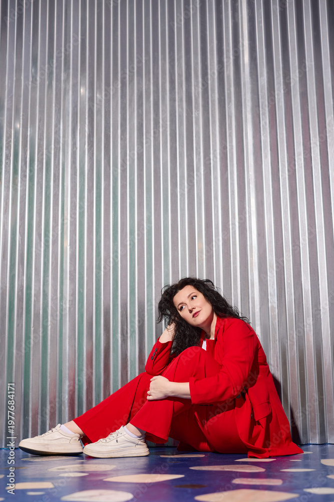 Obraz premium Chic woman in red exudes confident relaxed aura outdoors